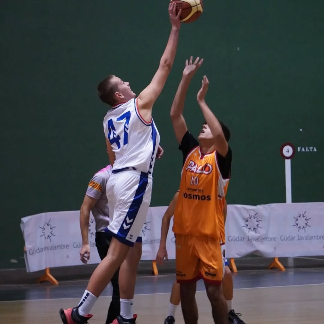 Pawel jumping for the ball during a basketball game.